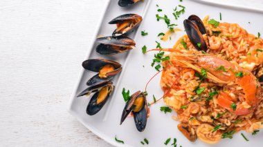 Risotto ile deniz ürünleri ve Kraliyet karides. Ahşap bir arka plan üzerinde. Üstten Görünüm. Metin için boş alan.