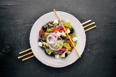 Yunan salatası. Ahşap arka plan üzerinde taze sebze. Üstten Görünüm. Metin için boş alan.