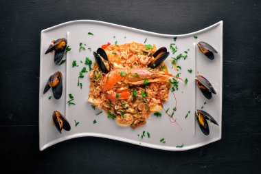 Risotto ile deniz ürünleri ve Kraliyet karides. Ahşap bir arka plan üzerinde. Üstten Görünüm. Metin için boş alan.