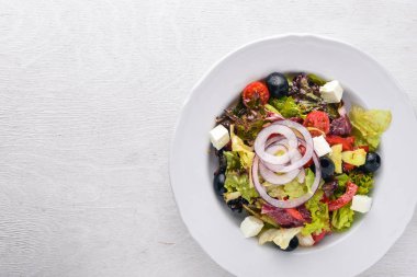 Yunan salatası. Ahşap arka plan üzerinde taze sebze. Üstten Görünüm. Metin için boş alan.