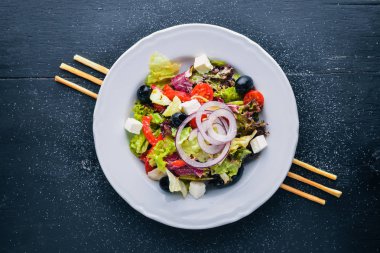 Yunan salatası. Ahşap arka plan üzerinde taze sebze. Üstten Görünüm. Metin için boş alan.