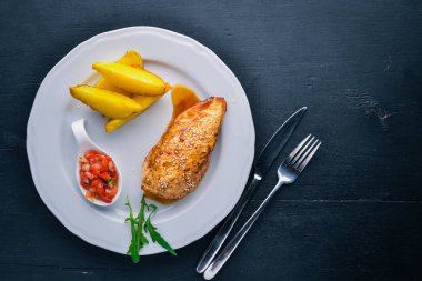 Tavuk biftek ve patates ahşap arka plan üzerinde. Üstten Görünüm. Metin için boş alan.