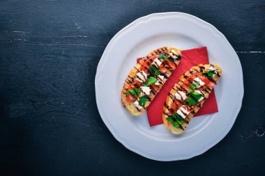 Domates sandviç ve beyaz peynir. Ahşap bir arka plan üzerinde. Üstten Görünüm. Metin için boş alan.