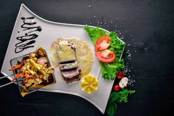 Dana biftek ve ızgara sebzeler. Ahşap bir arka plan üzerinde. Üstten Görünüm. Metin için boş alan.