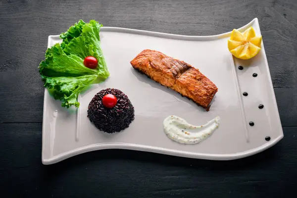 Yabani pirinç pişmiş somon fileto. Ahşap bir arka plan üzerinde. Üstten Görünüm. Metin için boş alan.