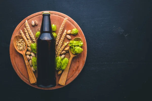 Uma garrafa de cerveja, lúpulo e cereais. Vista superior. Espaço livre para texto . — Fotografia de Stock