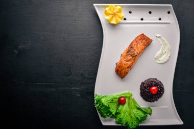 Yabani pirinç pişmiş somon fileto. Ahşap bir arka plan üzerinde. Üstten Görünüm. Metin için boş alan.