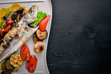 Alabalık ızgara sebze ile pişmiş balık. Ahşap bir arka plan üzerinde. Üstten Görünüm. Metin için boş alan.