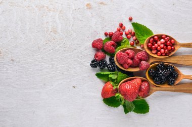 Çilek ürün yelpazesine. Ahududu, böğürtlen, çilek, kızılcık. Ahşap bir arka plan üzerinde. Üstten Görünüm. Metin için boş alan.
