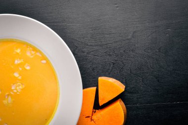 Balkabağı çorbası. Ahşap bir arka plan üzerinde. Üstten Görünüm. Metin için boş alan.