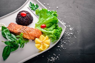 Yabani pirinç pişmiş somon fileto. Ahşap bir arka plan üzerinde. Üstten Görünüm. Metin için boş alan.