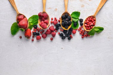 Çilek ürün yelpazesine. Ahududu, böğürtlen, çilek, kızılcık. Ahşap bir arka plan üzerinde. Üstten Görünüm. Metin için boş alan.