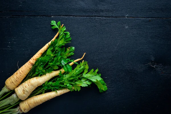 Peterselie. Root peterselie. Op een houten achtergrond. Bovenaanzicht. Vrije ruimte voor tekst. — Stockfoto