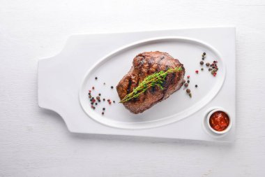 Dana biftek bir plaka üzerinde. Üstten Görünüm. Metin için özgür yer. Ahşap bir arka plan üzerinde.