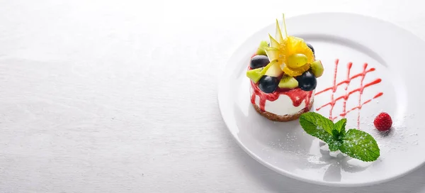 Bolo de queijo com frutas e bagas. Vista superior. Espaço livre para texto. Em um fundo de madeira . — Fotografia de Stock