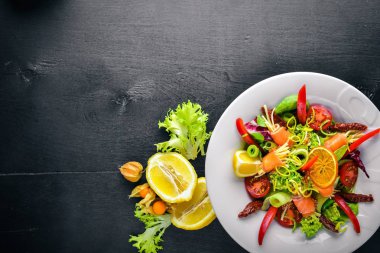 Salata somon ve taze sebze ve otlar. İtalyan mutfağı. Üstten Görünüm. Ahşap arka plan üzerinde.