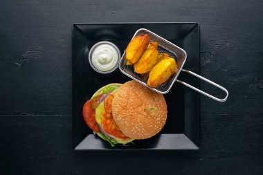Burger ve patates sos ile. Ahşap bir arka plan üzerinde. Üstten Görünüm. Metniniz için boş alan.
