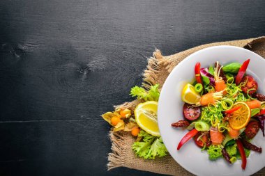 Salata somon ve taze sebze ve otlar. İtalyan mutfağı. Üstten Görünüm. Ahşap arka plan üzerinde.