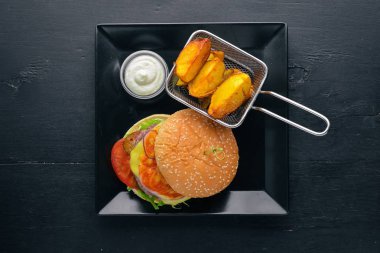 Burger ve patates sos ile. Ahşap bir arka plan üzerinde. Üstten Görünüm. Metniniz için boş alan.
