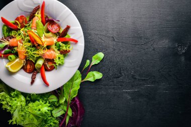 Salata somon ve taze sebze ve otlar. İtalyan mutfağı. Üstten Görünüm. Ahşap arka plan üzerinde.