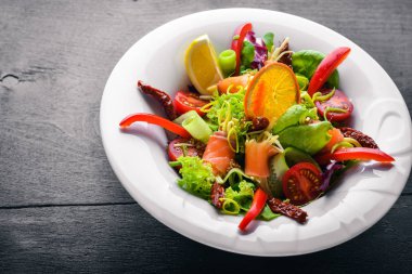 Salata somon ve taze sebze ve otlar. İtalyan mutfağı. Üstten Görünüm. Ahşap arka plan üzerinde.