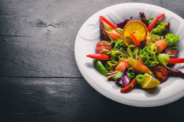 Salata somon ve taze sebze ve otlar. İtalyan mutfağı. Üstten Görünüm. Ahşap arka plan üzerinde.