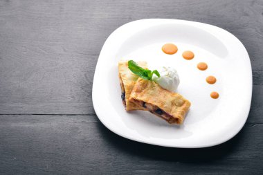 Apple Strudel dondurma ile. Ahşap bir arka plan üzerinde. Üstten Görünüm. Metniniz için boş alan.