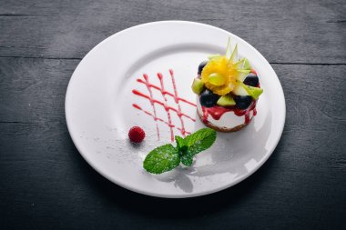 Peynirli kek meyve ve çilek ile. Üstten Görünüm. Metin için özgür yer. Ahşap bir arka plan üzerinde.