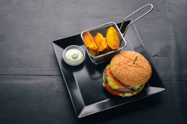 Burger ve patates sos ile. Ahşap bir arka plan üzerinde. Üstten Görünüm. Metniniz için boş alan.