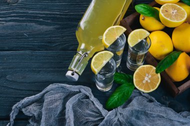 Tekila, taze limon ve limon suyu. Ahşap bir arka plan üzerinde. Üstten Görünüm. Metniniz için boş alan.