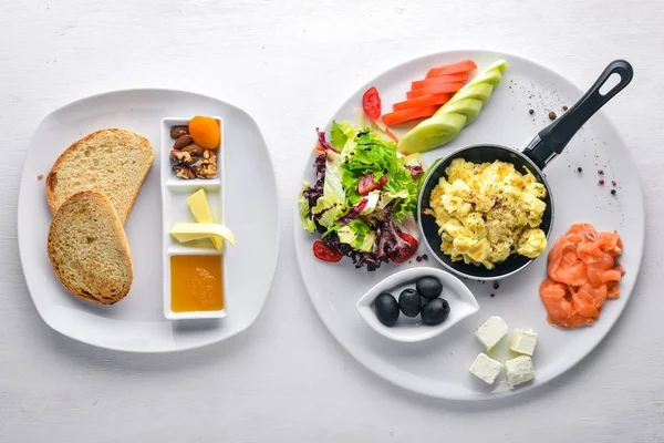 영어 아침 식사입니다. 튀긴 계란, 연어, 올리브, 견과류, 야채와 말린 과일 최고의 볼 수 있습니다. 텍스트에 대 한 여유 공간입니다. 나무 배경. — 스톡 사진