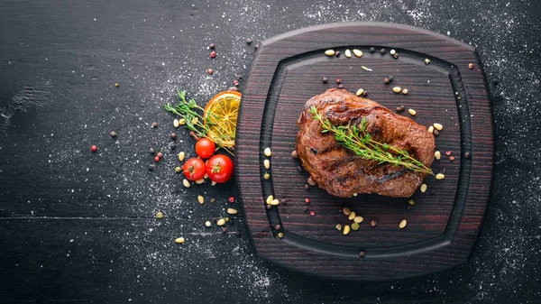 Steak de veau avec des épices sur la planche. Vue de dessus. Espace libre pour le texte. Sur un fond en bois . — Photo