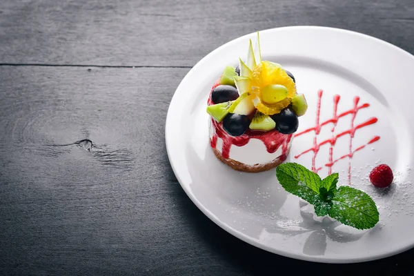 Peynirli kek meyve ve çilek ile. Üstten Görünüm. Metin için özgür yer. Ahşap bir arka plan üzerinde.