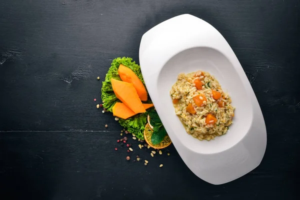 Risotto met pompoen. Bovenaanzicht. Vrije ruimte voor tekst. Op een houten achtergrond. — Stockfoto