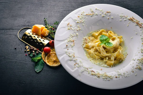 Pasta with cheese on a plate with the word "paste". Top view. Free space for text. On a wooden background. — Stock Photo, Image