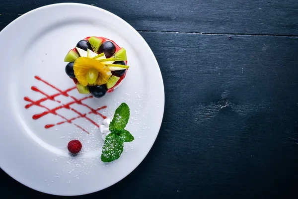 Peynirli kek meyve ve çilek ile. Üstten Görünüm. Metin için özgür yer. Ahşap bir arka plan üzerinde.