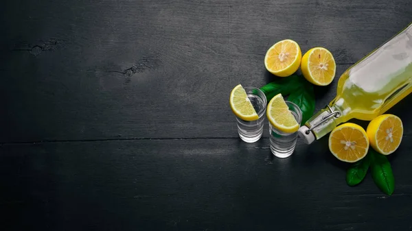 Tequila, limón fresco y jugo de limón. Sobre un fondo de madera. Vista superior. Espacio libre para tu texto . — Foto de Stock