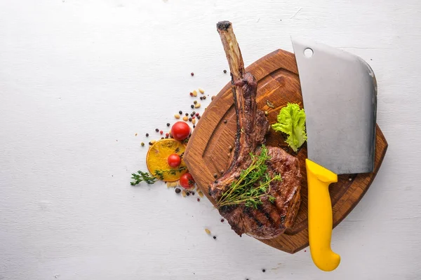 Steak on the bone. Top view. Free space for text. On a wooden background. — Stock Photo, Image