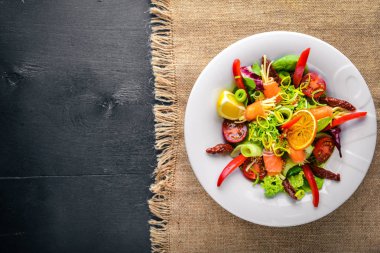 Salata somon ve taze sebze ve otlar. İtalyan mutfağı. Üstten Görünüm. Ahşap arka plan üzerinde.