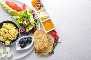 İngiliz kahvaltısı. Yumurta, zeytin, taze sebze, fındık, Kuru Meyve ve bal. Üstten Görünüm. Metin için özgür yer. Ahşap bir arka plan üzerinde.