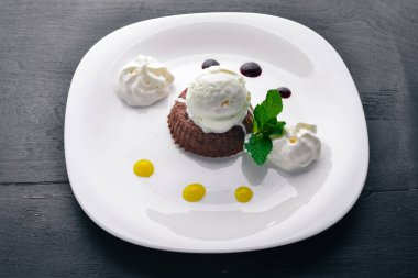 Çikolatalı pasta tatlı dondurma ile. Ahşap bir arka plan üzerinde. Üstten Görünüm. Metniniz için boş alan.