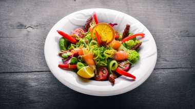 Salata somon ve taze sebze ve otlar. İtalyan mutfağı. Üstten Görünüm. Ahşap arka plan üzerinde.