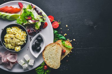 İngiliz kahvaltısı. Yumurta, zeytin, taze sebze, fındık, Kuru Meyve ve bal. Üstten Görünüm. Metin için özgür yer. Ahşap bir arka plan üzerinde.