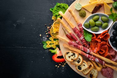 Soğuk aperatifler. Doğranmış sosis, pastırma, zeytin, zeytin. Üstten Görünüm. Ahşap arka plan. Metin için boş alan.