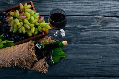 Bir şişe şarap ve üzüm. Ahşap bir arka plan üzerinde. Üstten Görünüm. Metniniz için boş alan.