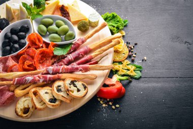Soğuk aperatifler. Doğranmış sosis, pastırma, zeytin, zeytin. Üstten Görünüm. Ahşap arka plan. Metin için boş alan.