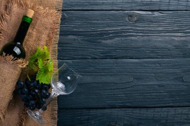 Bir şişe şarap ve üzüm. Ahşap bir arka plan üzerinde. Üstten Görünüm. Metniniz için boş alan.