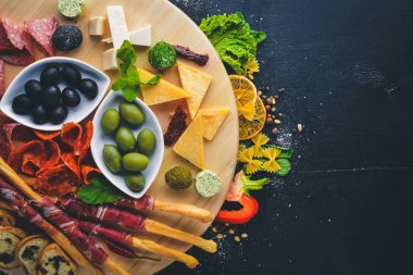 Soğuk aperatifler. Doğranmış sosis, pastırma, zeytin, zeytin. Üstten Görünüm. Ahşap arka plan. Metin için boş alan.