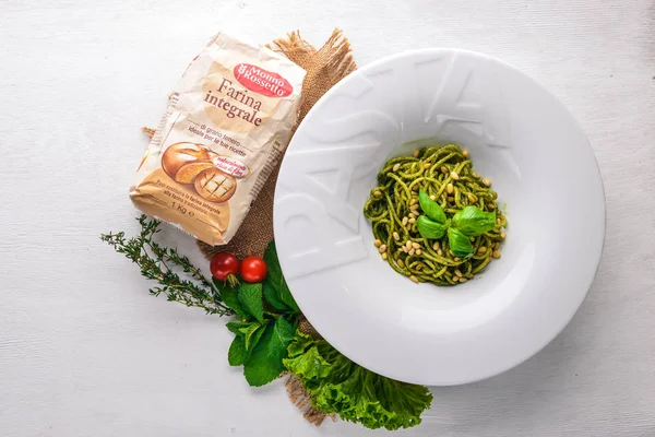 Pasta met pijnboompitten en Groenen. Bord met het woord "plakken". Bovenaanzicht. Vrije ruimte voor tekst. Op een houten achtergrond. — Stockfoto