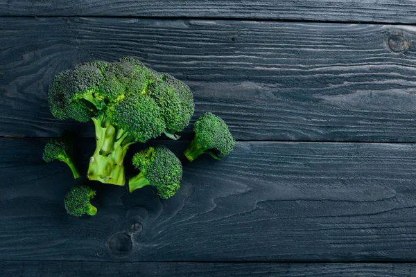 Broccoli. På en trä bakgrund. Ovanifrån. Fritt utrymme för din text. — Stockfoto
